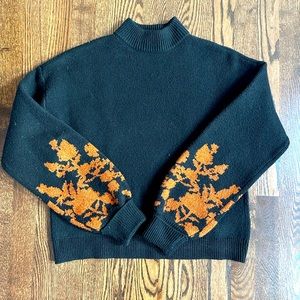 Black turtleneck sweater with copper floral sleeve detail